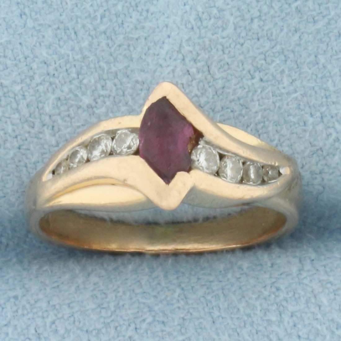 Vintage Ruby & Diamond Ring in 14k Rose Gold: In 14k rose gold. Contains one high quality natural 5.5mm Ruby gemstone with intense color and excellent clarity. Chip on edge of stone, indicative of age. Also contains eight high quality diamonds, 0