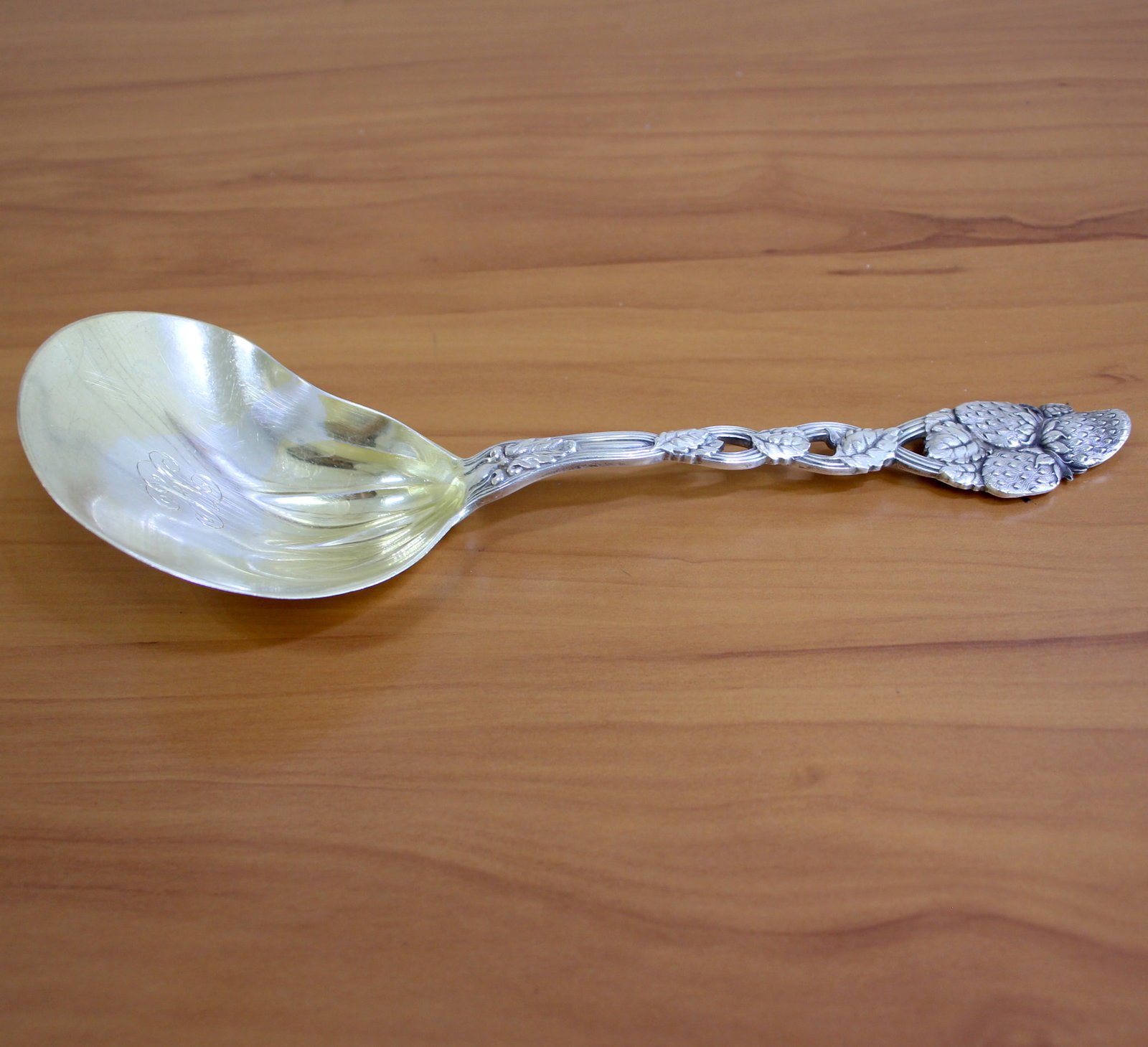 Tiffany and Co Sterling "Strawberry" Large Sterling Silver Casserole Spoon: In .925 Sterling Silver. Contains one berry casserole large spoon with kidney shaped bowl. 9.5 inches long. Monogrammed. 121.8g.