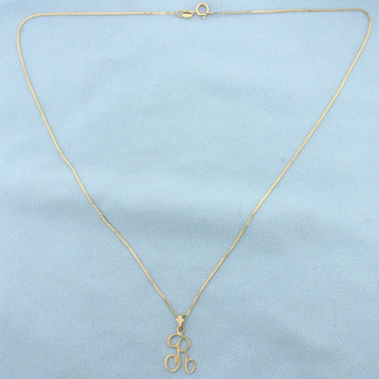 R Initial Necklace in 14k Yellow Gold: In 14k Yellow Gold. "R" pendant is 7/8 inch long by 1/2 wide. Chain is 18.5 inch long, 1mm wide. S-link. Spring clasp. 2.3g.