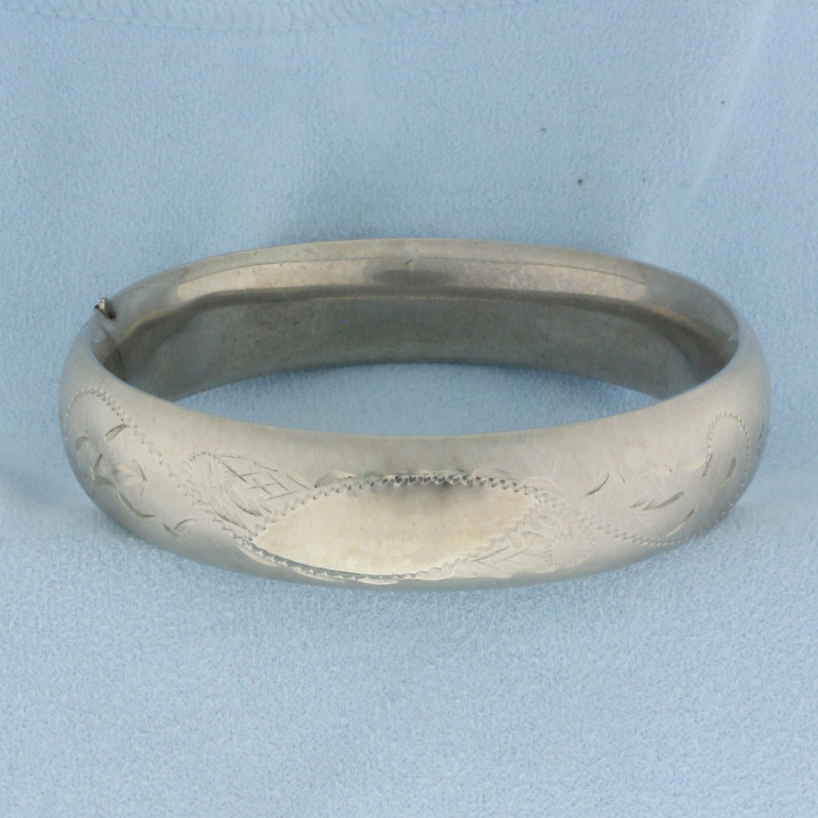 Bangle Bracelet in Sterling Silver: In .925 sterling silver. 2 1/2 inch inner diameter and 15mm wide. Opens and closes for easy putting on/taking off. 28.4g.
