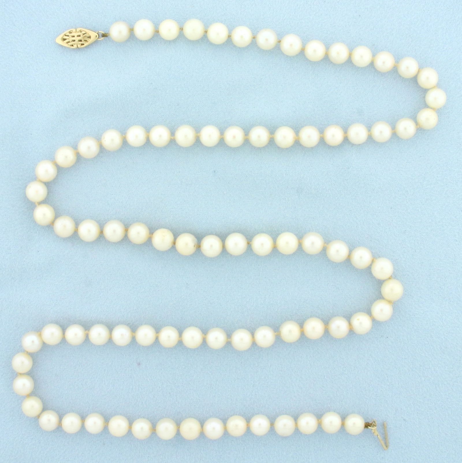 Vintage Cultured Akoya Pearl Strand Necklace in 14k Yellow Gold: 14k yellow gold clasp. 25inches long. 6.7mm cultured akoya pearls with high luster. Hand knotted. Decorative filigree locking clasp.
