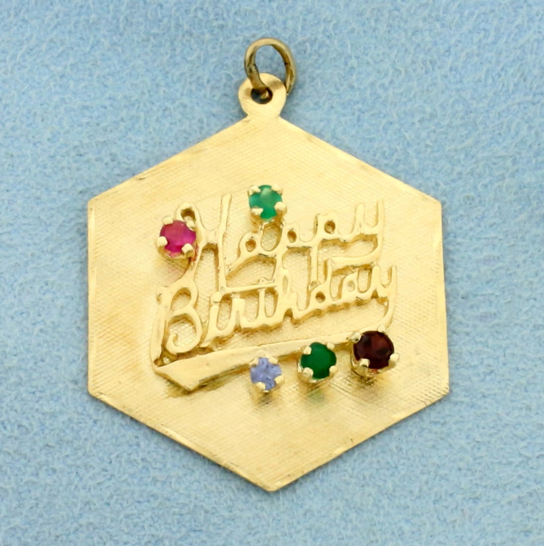 Happy Birthday Pendant with Ruby, Emerald, and Sapphire in 14K Yellow Gold: In 14K Yellow Gold. Contains five 2.5mm to 3.0mm gemstones two emeralds, one ruby, one pink sapphire, and one blue sapphire. All high quality, natural gemstones with vivid color. 1 1/2 inches long wit