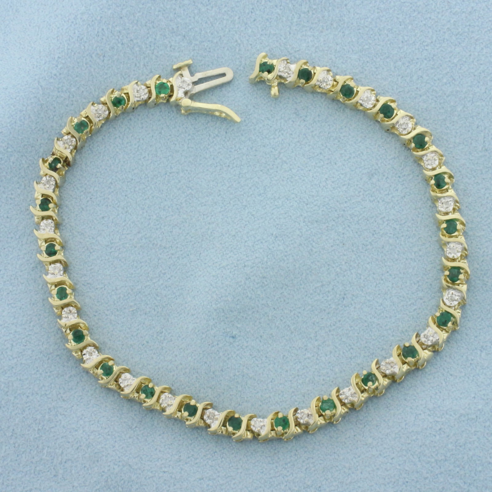 Emerald and Diamond S-Link Tennis Bracelet in 14k Yellow Gold: In 14k yellow gold. Contains twenty-six high quality natural 2mm Emerald gemstones, 1ct TW, with intense color. Also contains twenty-six high quality 1/2pt diamonds. 7 1/4 inches long and 4.5mm wide. 