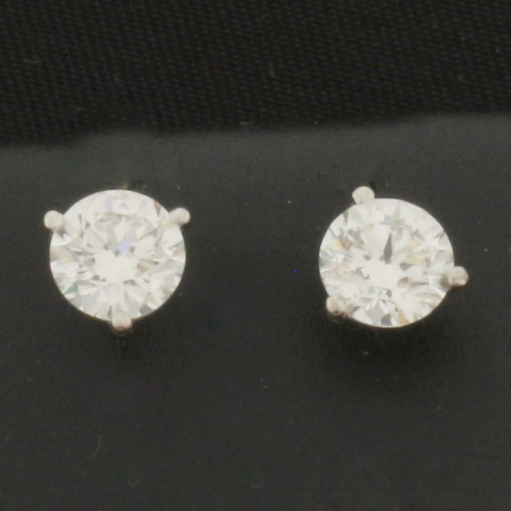 GIA Certified 1ct TW Diamond Stud Earrings in Platinum Martini Settings: In platinum martini settings. Contain two 1/2ct GIA certified round brilliant diamonds, H color/SI2 clarity, eye clean, triple excellent cut for maximum sparkle, and no fluorescence. Friction backs.