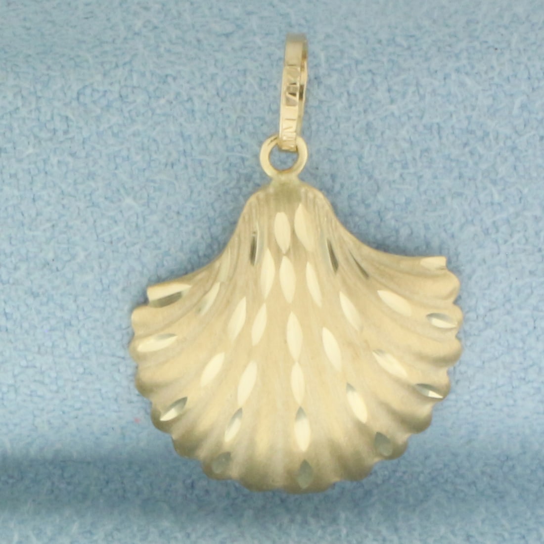 Seashell Charm in 14k Yellow Gold: In 14k yellow gold. 7/8 inch long by 5/8 inch wide. .7g.