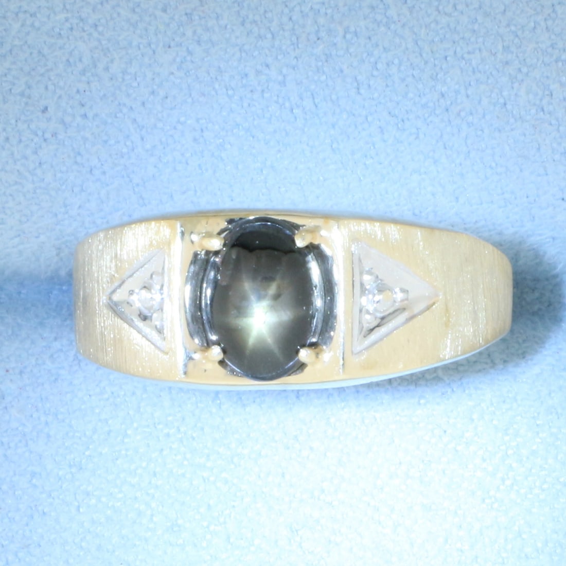 Mens Back Star Sapphire Ring in 10k Yellow Gold: In 10k yellow gold. Contains one high quality 8mm by 6mm black Star Sapphire with distinct "star" under light. 9mm wide at center. Size: 12. 3.2g.