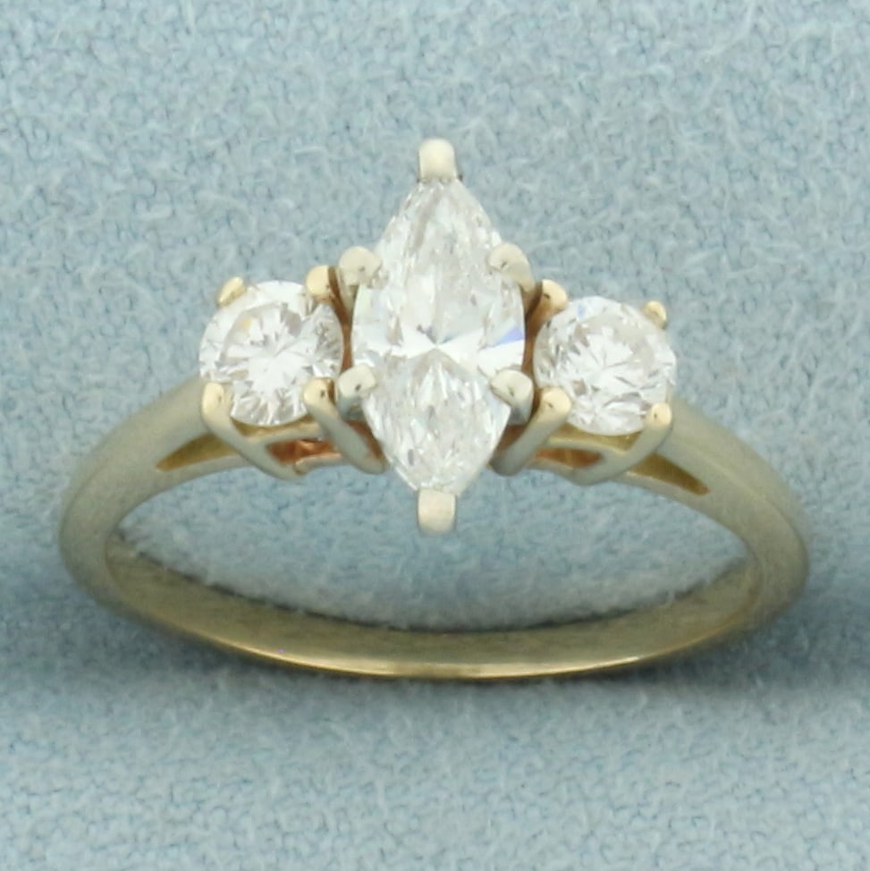 Marquise 3-Stone Engagement Ring in 14k Yellow Gold: In 14k yellow gold. Contains 1 high quality 3/4ct marquise cut diamond, SI clarity/H color. Also contains 2 high quality round diamonds, 1/3ct TW, of similar high quality. Size: 6. 2.6g.