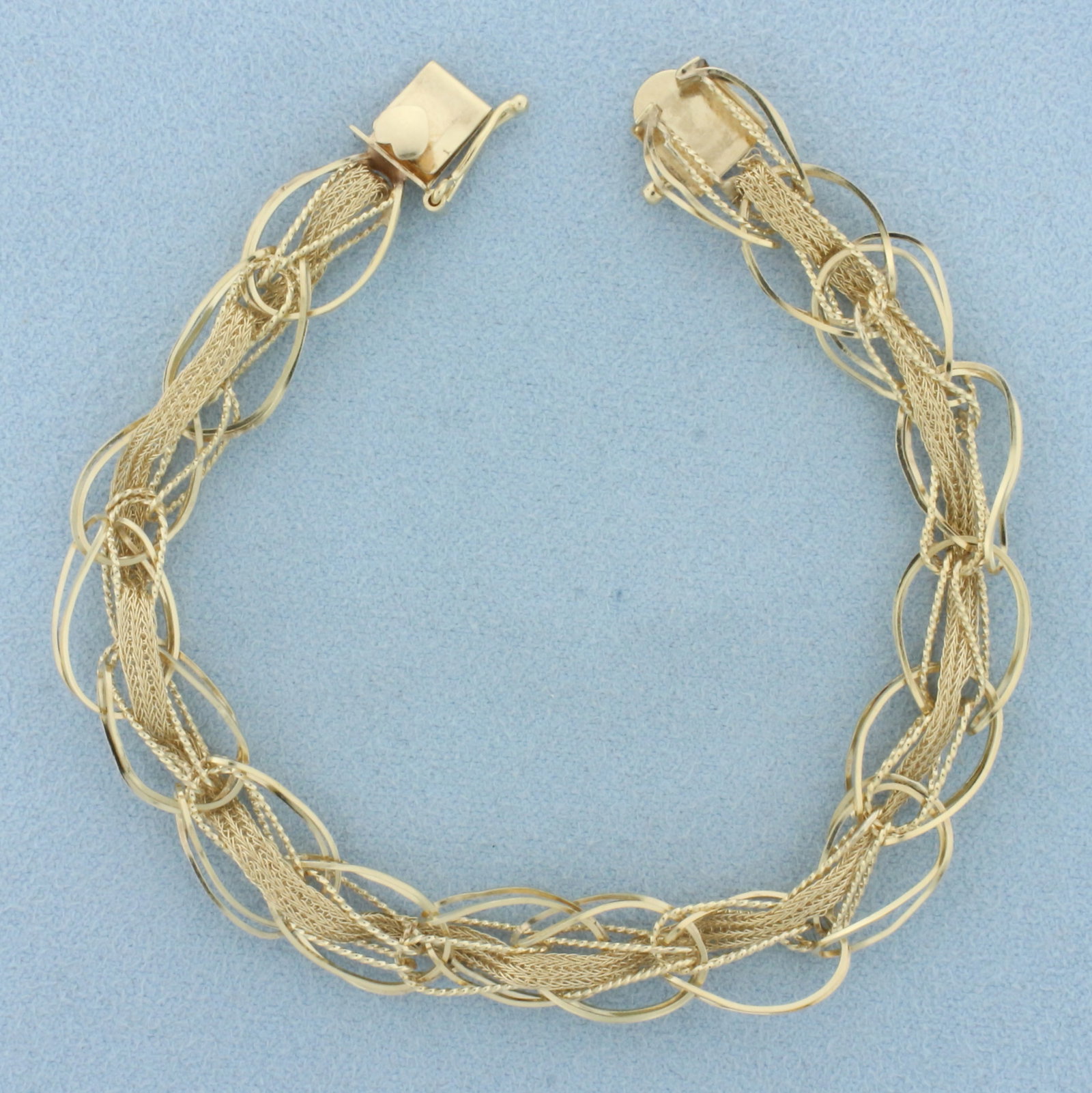 Unique Oval and Wheat Link Charm Bracelet in 14k Yellow Gold: In 14k yellow gold. 7 1/4 inches long and 3/4 inches wide. Plenty of places to hang charms on both sides. Wheat link chain threads through oversized oval links. Slide clasp with heart detail and safet