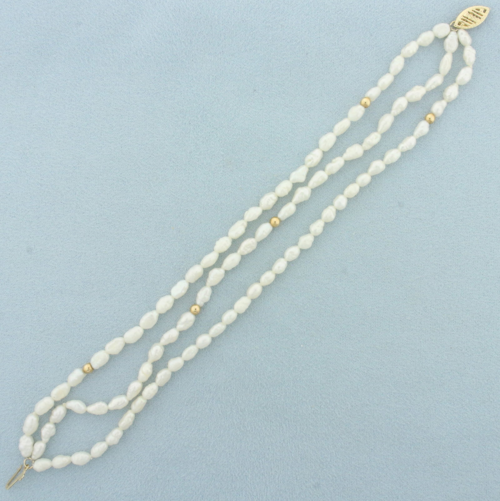 Triple Strand Baroque Pearl and Gold Bead Bracelet in 14k Yellow Gold: In 14k yellow gold. Filigree locking clasp and 3mm gold ball beads. Freshwater pearls are approx. 6x3mm each. 7 inches long. 9.0g.