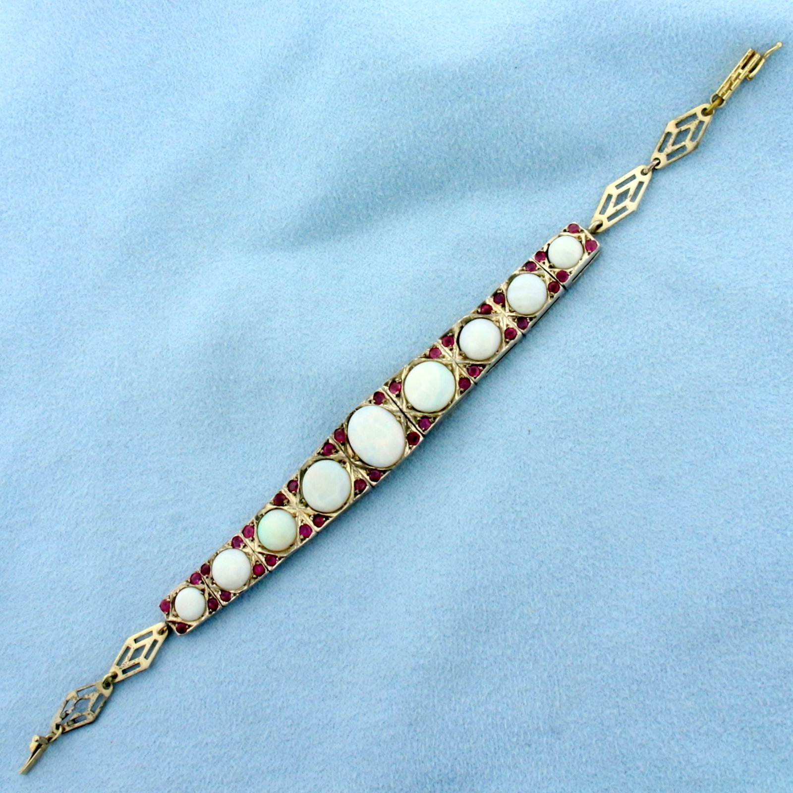 Antique Opal and Ruby Bracelet In 14k Yellow Gold and Sterling Silver: 14k Yellow Gold Links/Clasp and .925 Sterling Silver center. Contains one 11mmx9mm, two 8mm, two 7mm, two 6.75mm, and two 6mm high quality natural Opal Gemstones with intense play of color with flashe