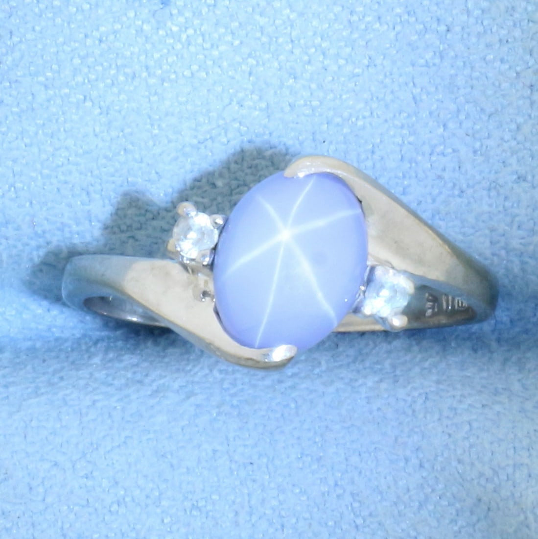 Star Sapphire and Diamond Ring in 10k White Gold: In 10k White Gold. Contains one high quality 8mmx6mm Star Sapphire gemstone with distinct "Star" under light. Also contains two high quality .02ct diamonds, SI clarity/H color. Size 6. 1.9g.