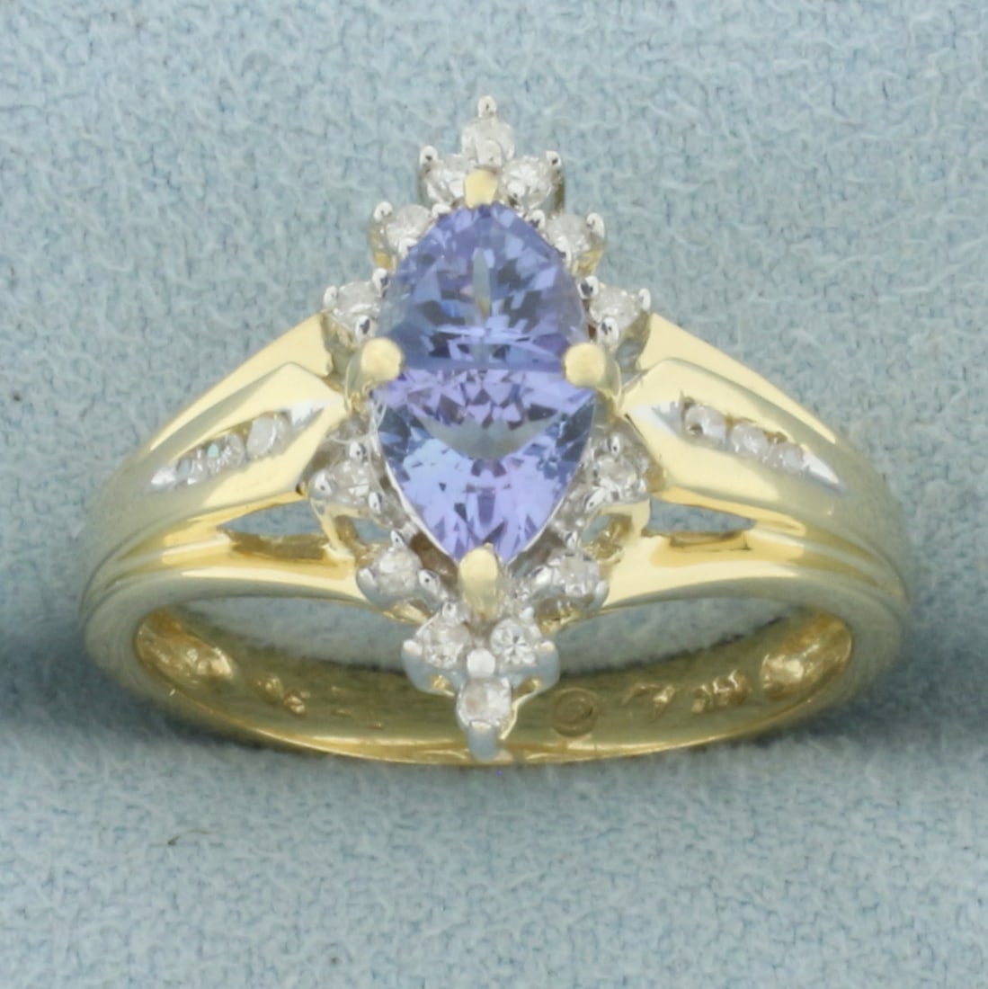 Unique Tanzanite and Diamond Ring in 14k Yellow Gold: In 14k yellow gold. Contains two 5mm high quality trillion cut tanzanite gemstones with vibrant color and excellent clarity. Alson contains twenty high quality 1/2pt diamonds. Size: 7.25. 3.8g.