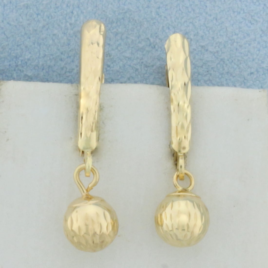 Ball Bead Dangle Earrings in 14k Yellow Gold: In 14k Yellow Gold. 6mm gold balls. 7/8 inch long. 3/8 inch wide. 1.0g.