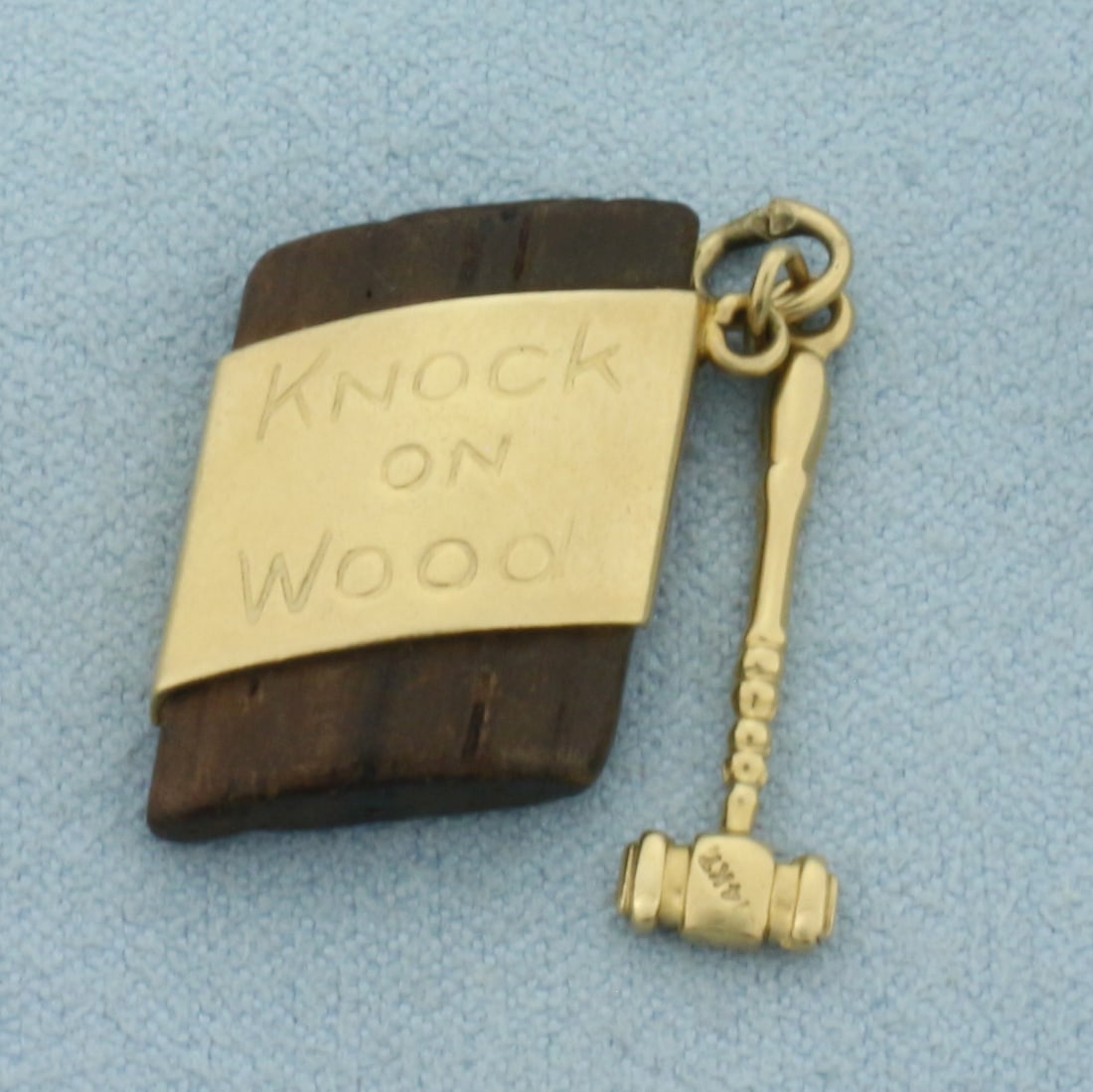 Knock on Wood Charm or Pendant in 14k Yellow Gold: In 14k Yellow Gold. Contains real wood piece. 3/4 inch long by 1/2 inch wide wood piece. 7/8 inch long by 1/4 inch wide gold hammer. 2.9g.