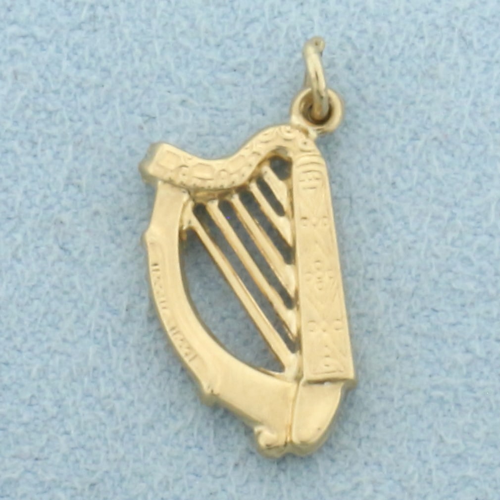 Harp Charm in 14k Yellow Gold: In 14k Yellow Gold. 3/4 inch long including jump ring. 3/8 inch wide at widest. 0.6g.