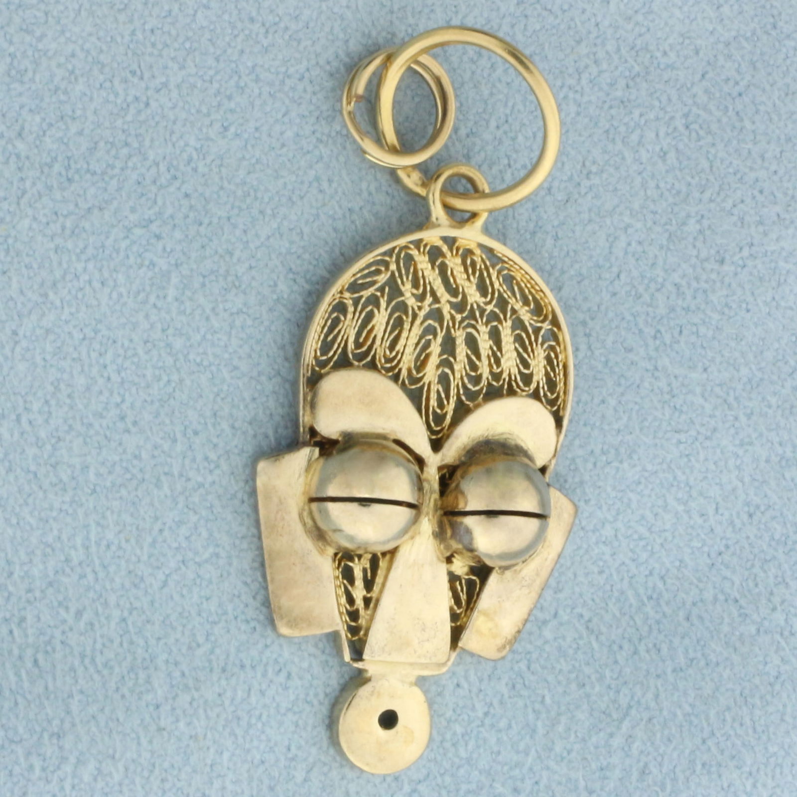 African Mask Charm or Pendant in 18k Yellow Gold: In 18k yellow gold. 1 7/8 inches long (including jump ring) x 3/4 inches wide. 4.6g.