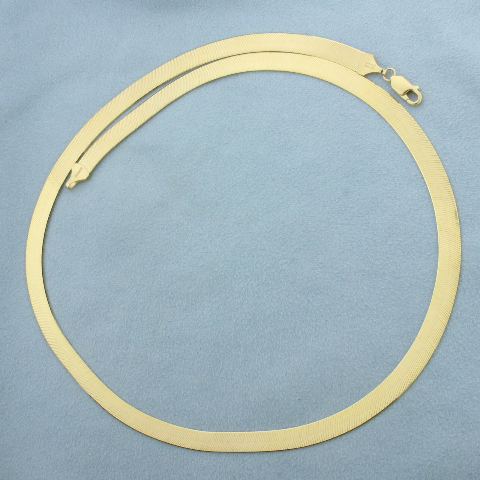 Italian 20 Inch Liquid Gold Herringbone Link Chain Necklace in 14k Yellow Gold: In 14k Yellow Gold. 20 inches long. 5.9mm wide. Italian made. Lobster clasp. 14.8g.