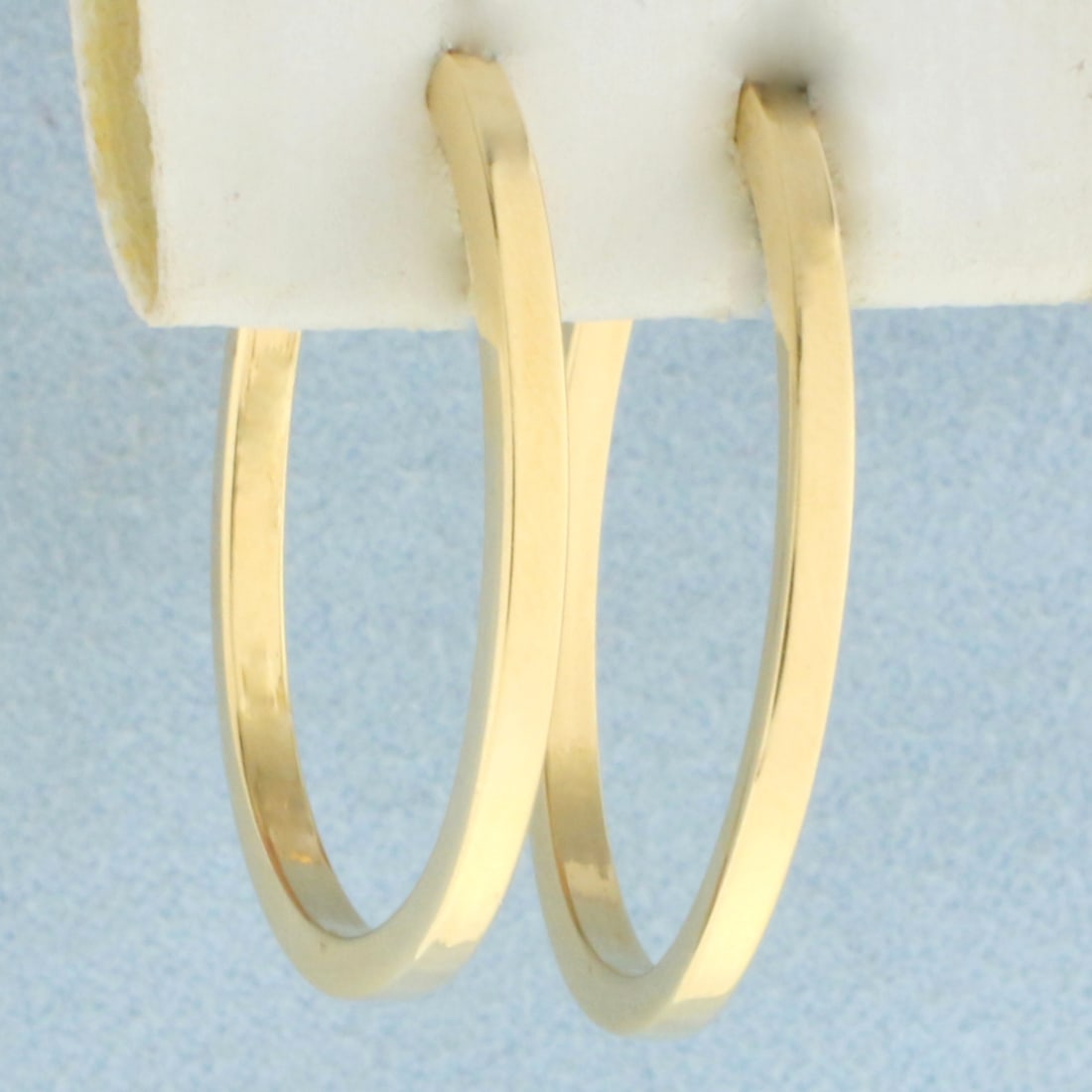 Oval Hoop Earrings in 14k Yellow Gold: In 14k Yellow Gold. 1 1/8 inch long. 7/8 inch wide. 2mm thick. Lever backs. 1.3g.