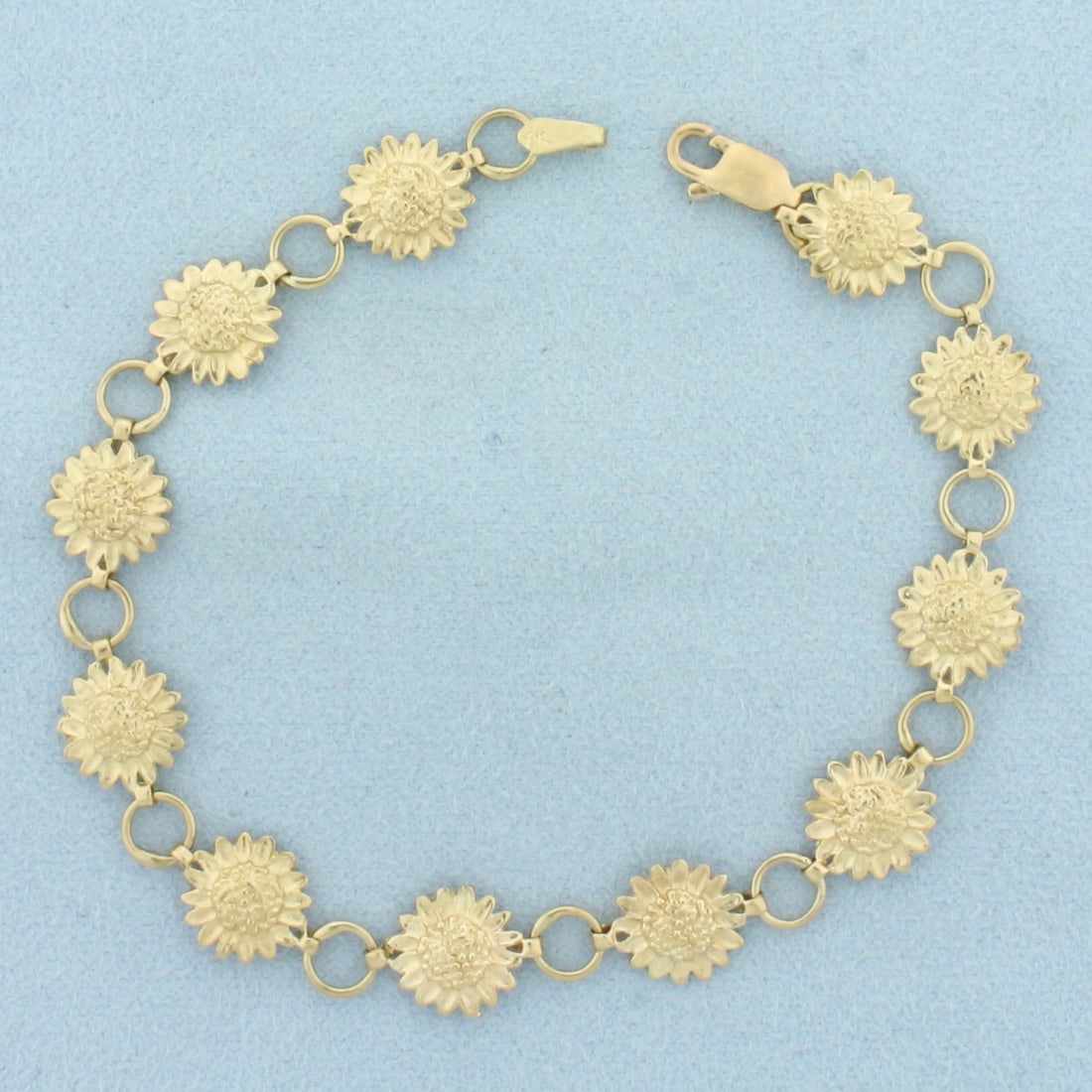 Sunflower Link Bracelet in 10k Yellow Gold: In 10k Yellow Gold. 7.5 inches long. 3/8 inch wide. Lobster clasp. 5.7g.