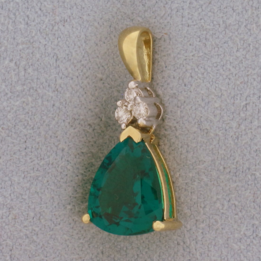 Green Garnet and Diamond Pendant in 10k Yellow Gold: In 10k Yellow Gold. Contains one high quality Green Garnet 10mmx8mm Green Garnet gemstone with excellent clarity and intense color. Also contains three .02ct diamonds, H color/I clarity. 3/4 inch long