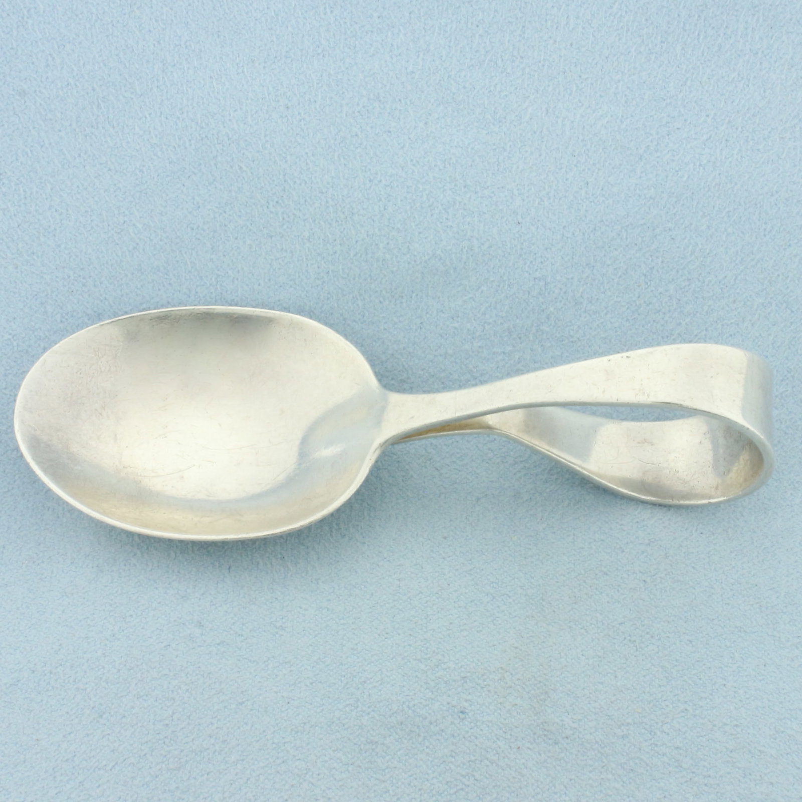 Sterling Silver Curved Baby Spoon: In .925 Sterling Silver. 3 1/2 inches long curved handle baby spoon. 22.8g.