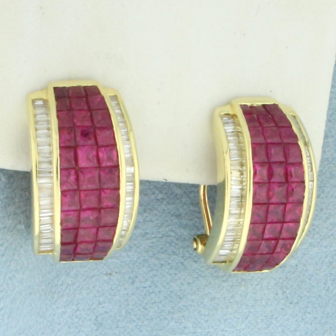 Invisible Set Ruby and Diamond Hoop Earrings in 18k Yellow Gold: In 18k Yellow Gold. Contains sixty-six 2 to 2.5mm high quality natural princess cut Ruby gemstones, 4ct TW, with intense color and excellent clarity. Also contains ninety-two 1.75mm high quality bague
