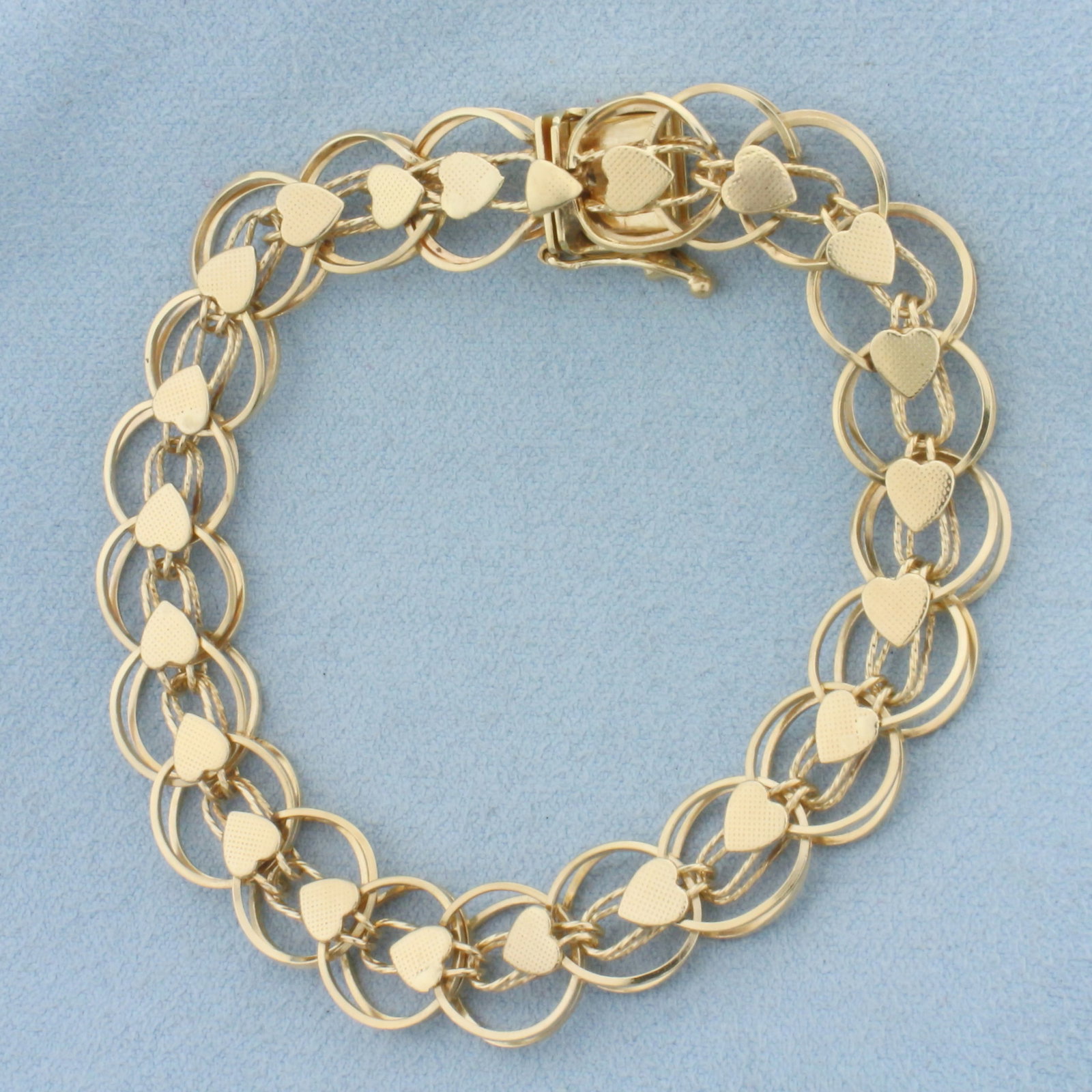 Heart Link Charm Bracelet in 14k Yellow Gold: In 14k Yellow Gold. 7 3/8 inches long. 11.3mm wide. Slide clasp with safety latch. 15.9g.