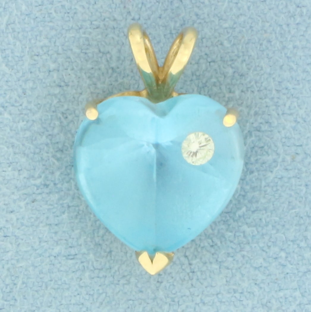 Lab Blue Sapphire and Diamond Heart Pendant in 14k Yellow Gold: In 14k yellow gold. Contains one heart cut 13mm Lab Created Blue Sapphire gemstone with pastel light blue color and excellent clarity. Also contains one high quality .07ct diamond, SI clarity/K color.