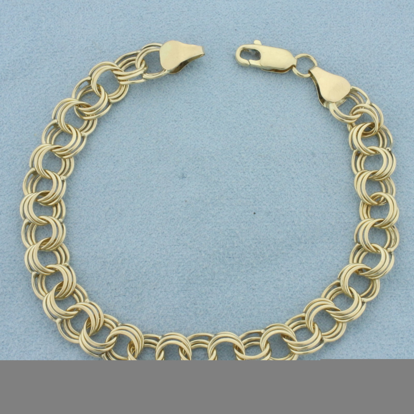 Triple Loop Charm Bracelet in 14k Yellow Gold: In 14k yellow gold. 7 1/2 inches long and 1/4 inch wide. Lobster clasp. 9.4g.
