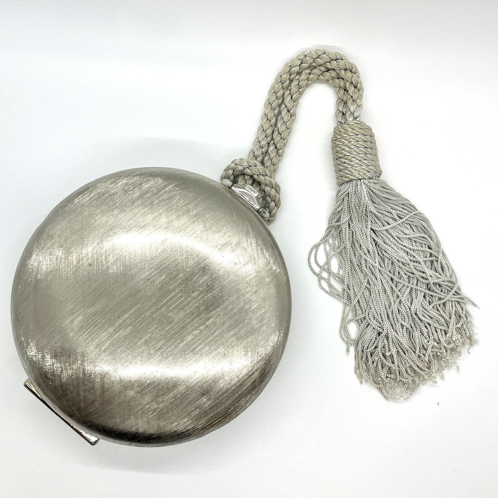 Vintage Judith Leiber Silver Disc Tassel Bag: Guaranteed authentic. Unique florentine finish on the silver tone metal hinged clutch. Push button top opens divided compartment with optional chain strap and mini mirror accessory (not shown in photo