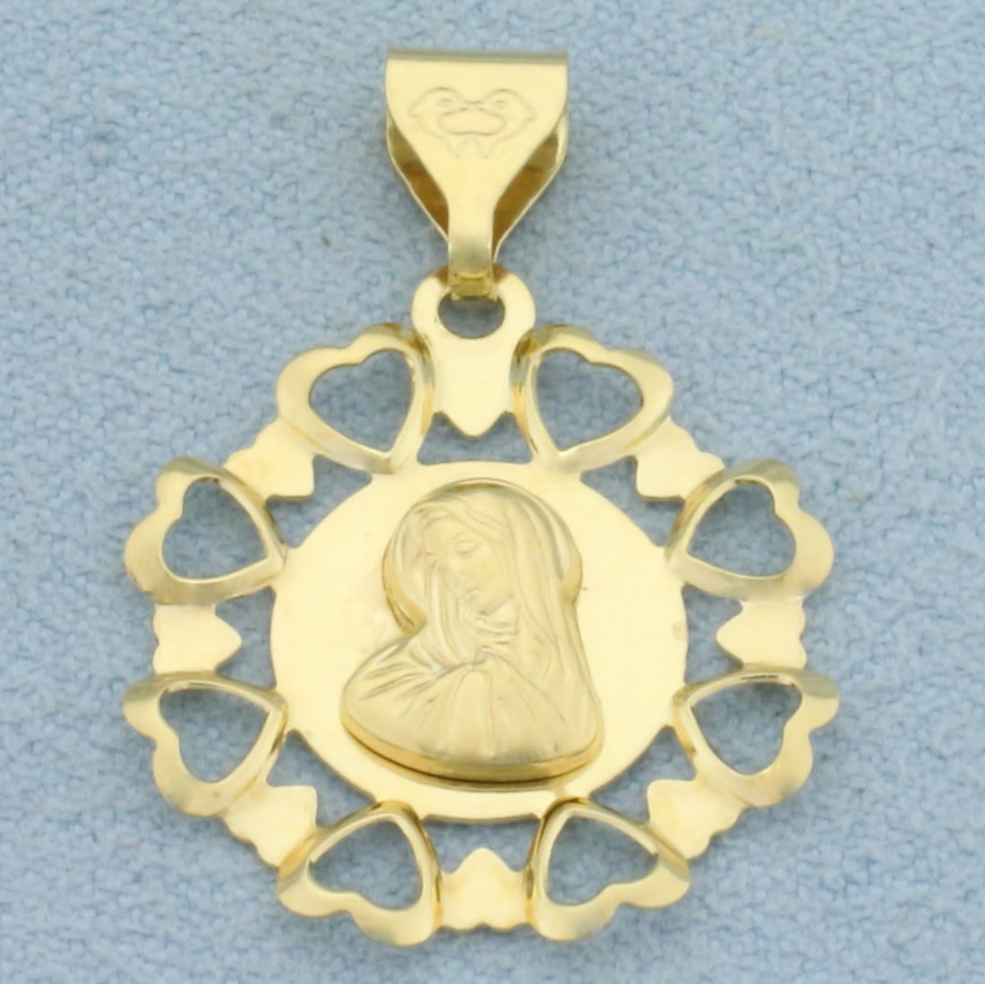 Virgin Mary Pendant in 18k Yellow Gold: In 18k Yellow Gold. 1 1/8 inch long including bale. 3/4 inch wide. 1.6g.