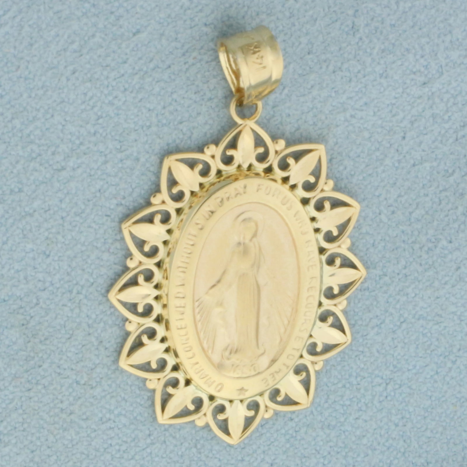 Miraculous Medal Virgin Mary Pendant in 14k Yellow Gold: In 14k Yellow Gold. 1 3/8 inch long including bale. 7/8 inch wide. 2.3g.