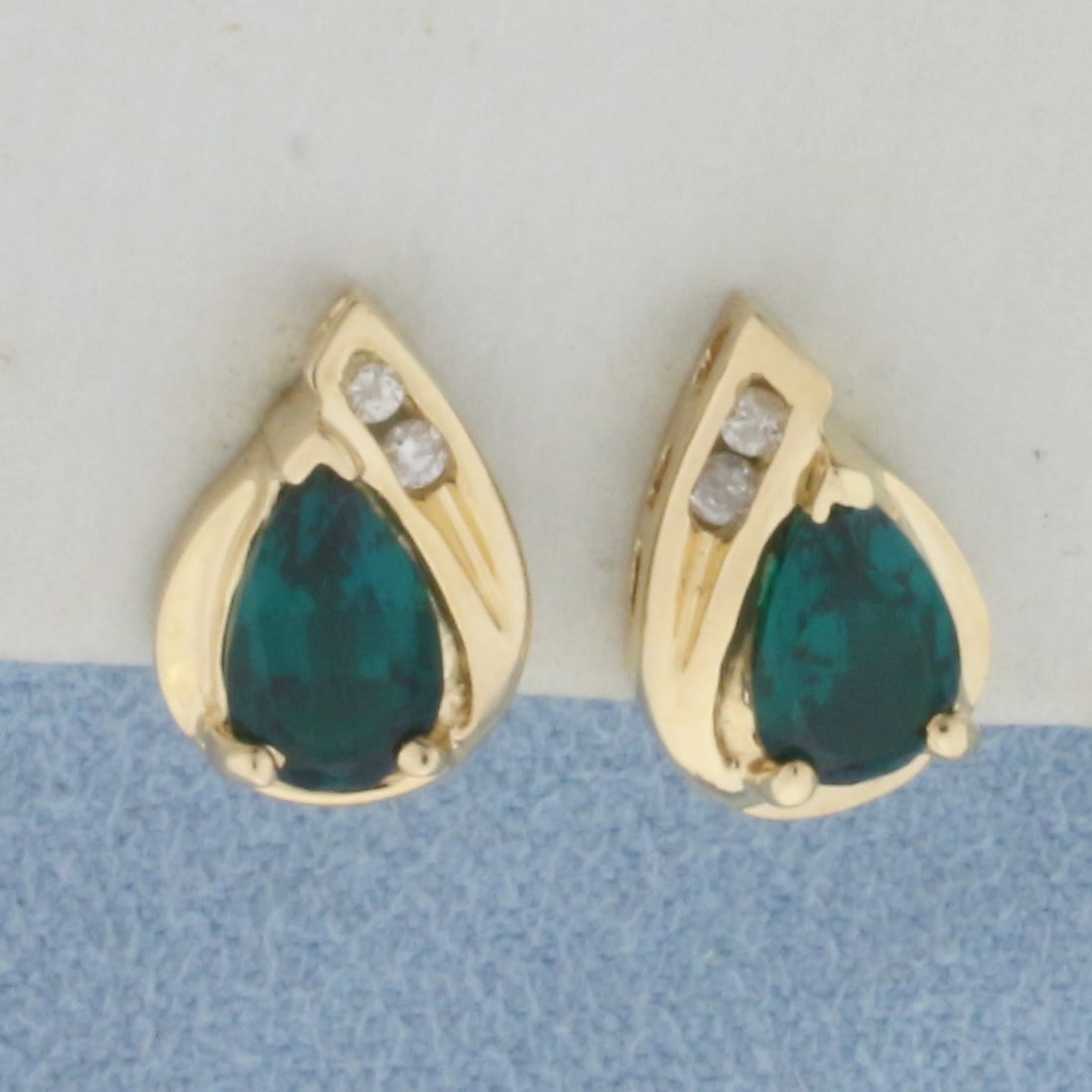 Tsavorite Garnet and Diamond Earrings in 14k Yellow Gold: In 14k Yellow Gold. Contains two high quality natural 5x7mm pear cut Tsavorite Garnet gemstones with beautiful Emerald green color and excellent clarity. Also contains four .02ct diamonds, SI clarity/