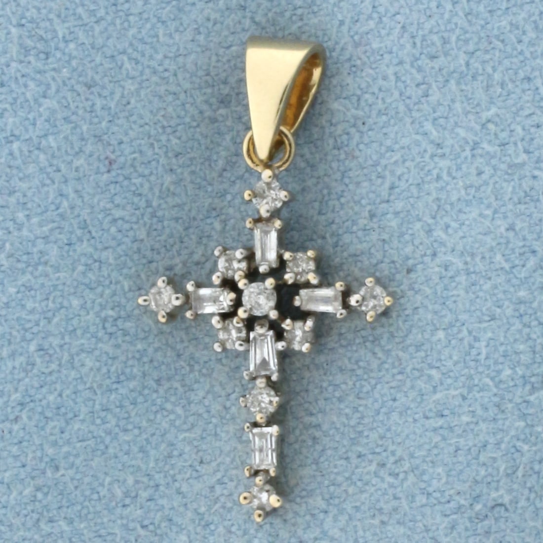 Diamond Cross Pendant in 10k Yellow Gold: In 10k Yellow Gold. Contains ten round and five baguette high quality diamonds, 1/4ct TW, I color/I clarity. 1 inch long including bale. 1/2 inch wide. 1.4g.