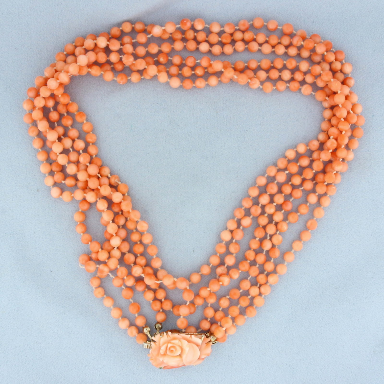 Angel Skin Pink Coral Necklace: 33 inches long. 4.7mm wide beads. Carved coral flower embellished clasp.