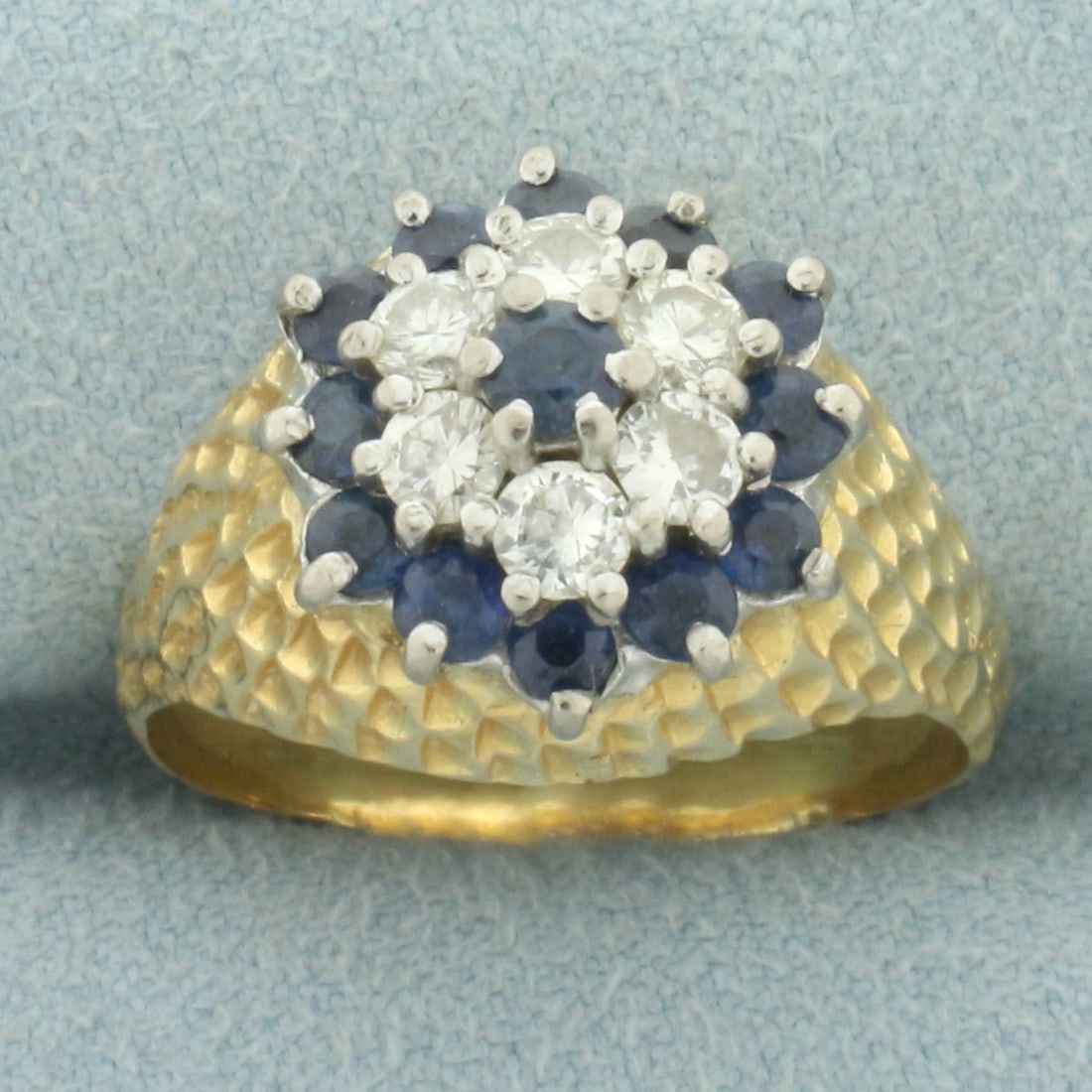 Sapphire and Diamond Flower Bombe Ring in 18k Yellow Gold: In 18k yellow gold. Contains thirteen high quality natural Sapphire gemstones, 2.25 to 3mm each, with intense color and excellent clarity. Also contains six high quality 1/10ct diamonds, SI clarity/H 