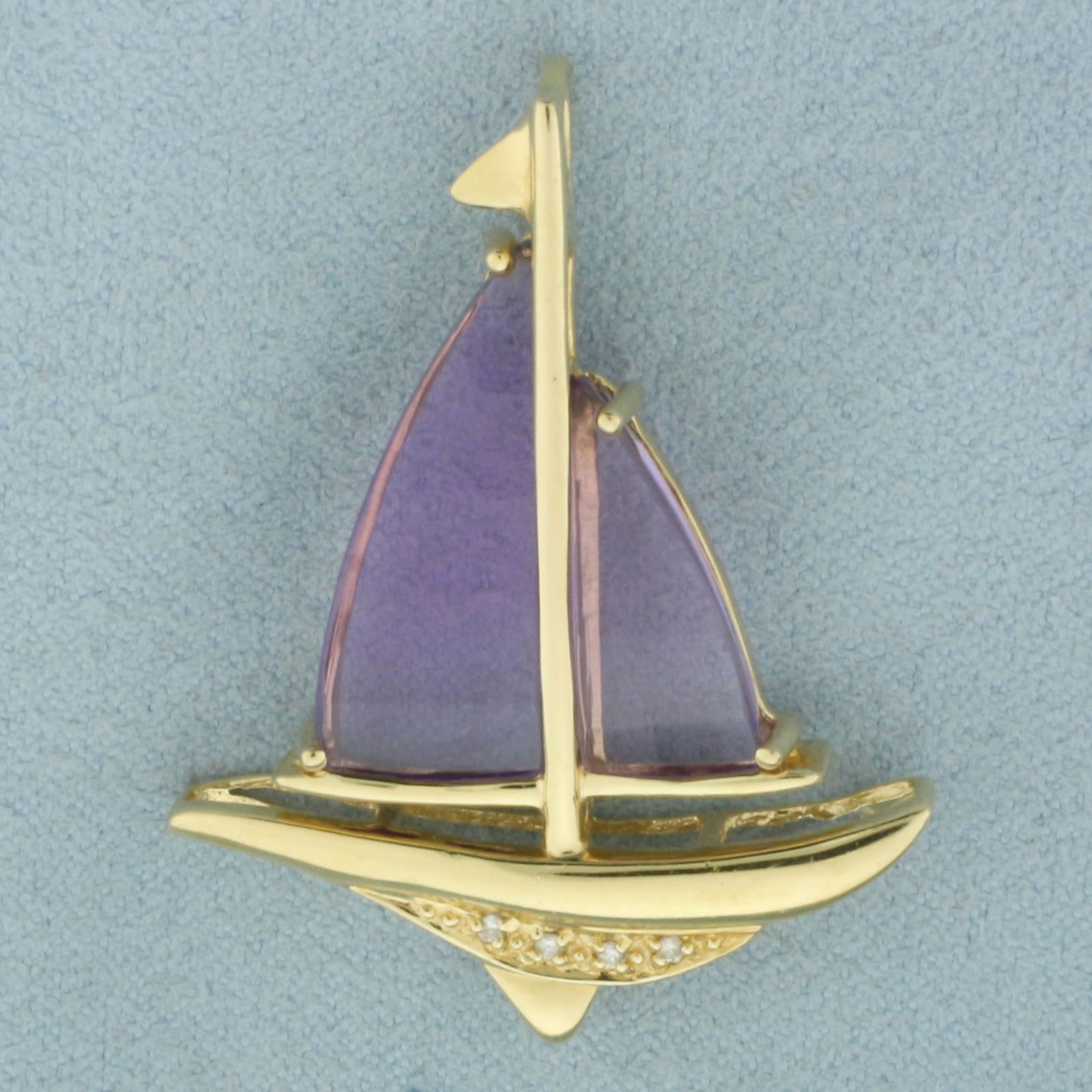 Amethyst and Diamond Sailboat Pendant in 14k Yellow Gold: In 14k Yellow Gold. Contains one 22x10mm and one 16x8mm high quality fancy cut natural Amethyst gemstone sails, with bright color and excellent clarity. Also contains four 1/2pt high quality diamonds.