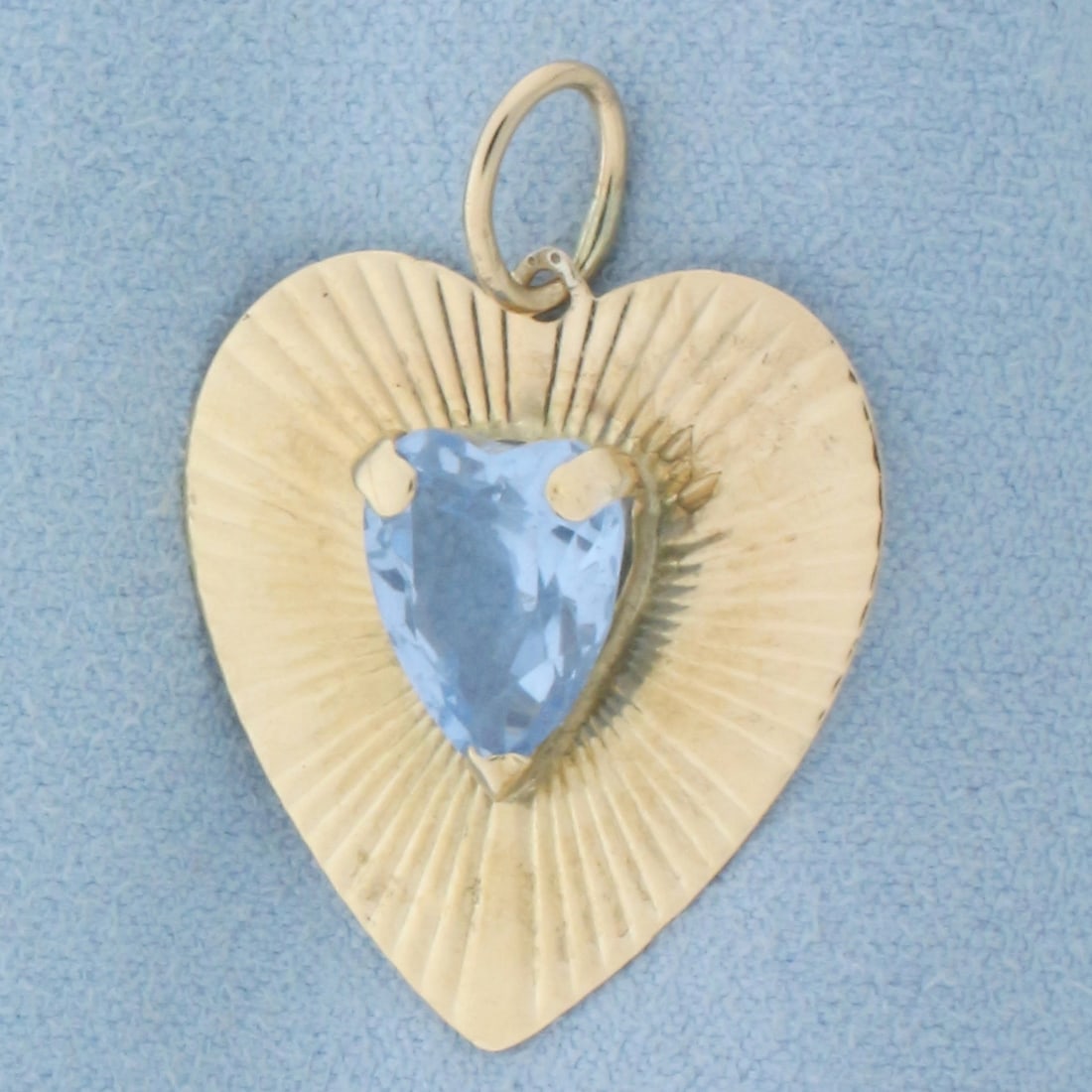 Heart Blue Topaz Pendant in 14k Yellow Gold: In 14k yellow gold. Contains one high quality natural 9mm by 11mm heart cut Sky Blue Topaz gemstone with vibrant color and excellent clarity. 1 1/4 inches long (including jump ring) and 1 inch wide. 3