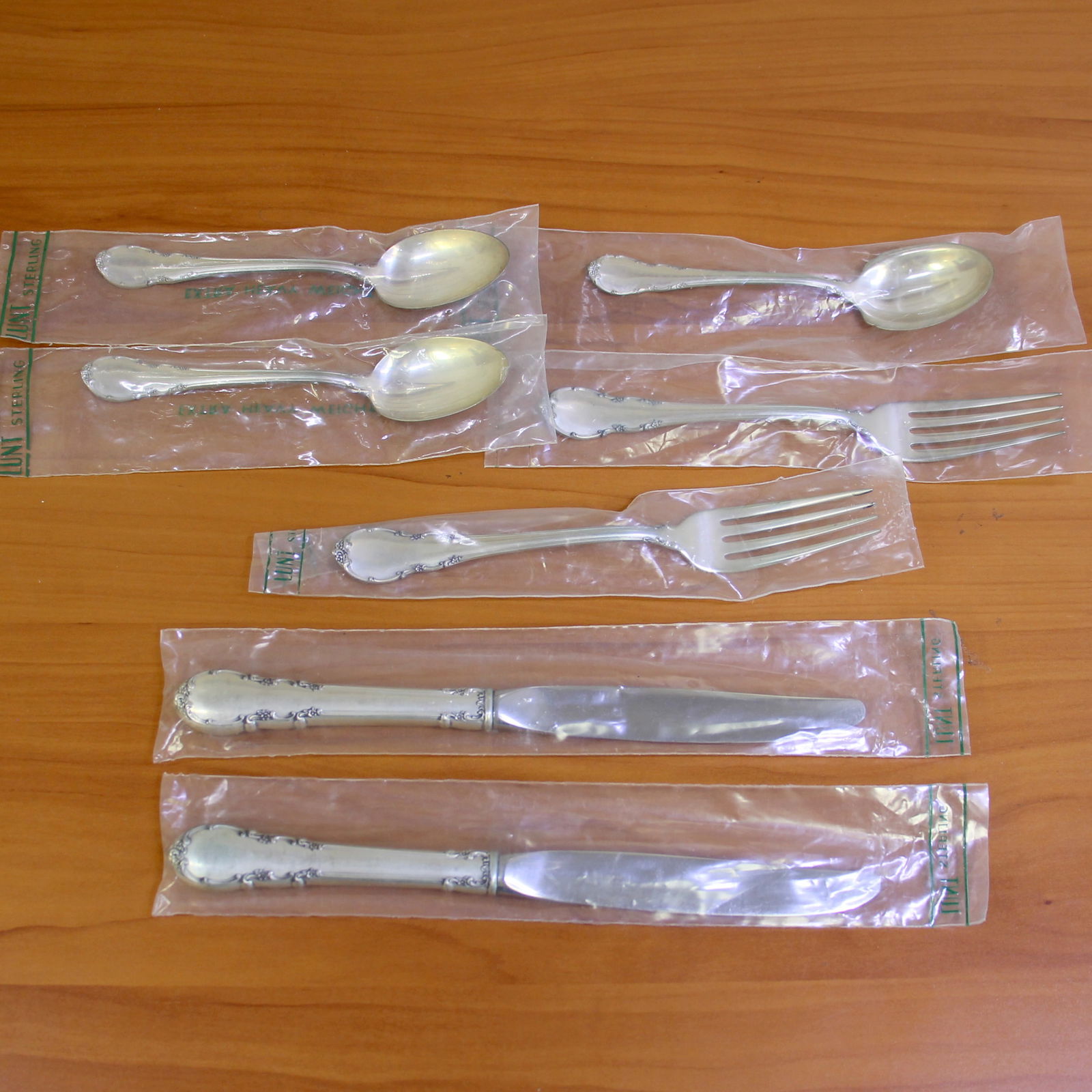 Lunt Modern Victorian 7 Piece Flatware Set in Sterling Silver: In sterling silver. In original sealed wrappers in excellent condition. Set includes two teaspoons 6 inches long, two forks 7.25 inches long, two knives 5 7/8 inches long, and one sugar shell spoon 5