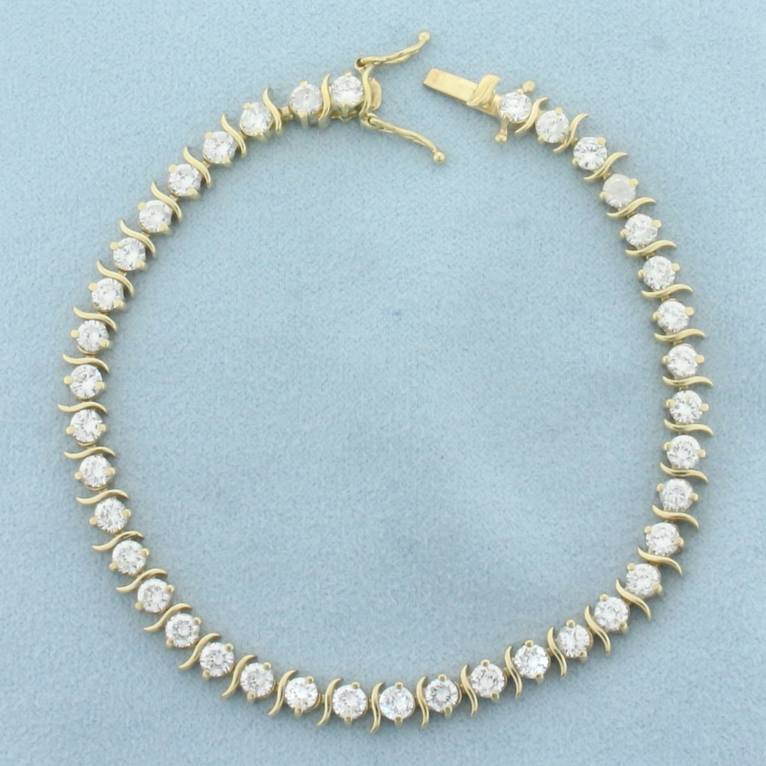 6ct CZ S Link Tennis Bracelet in 14k Yellow Gold: In 14k yellow gold. Contains thirty-nine high quality CZ gemstones, 6ct TW, with excellent cut and clarity for added brilliance. 7 5/8 inches long and 5.5mm wide. Concealed slide clasp with double saf