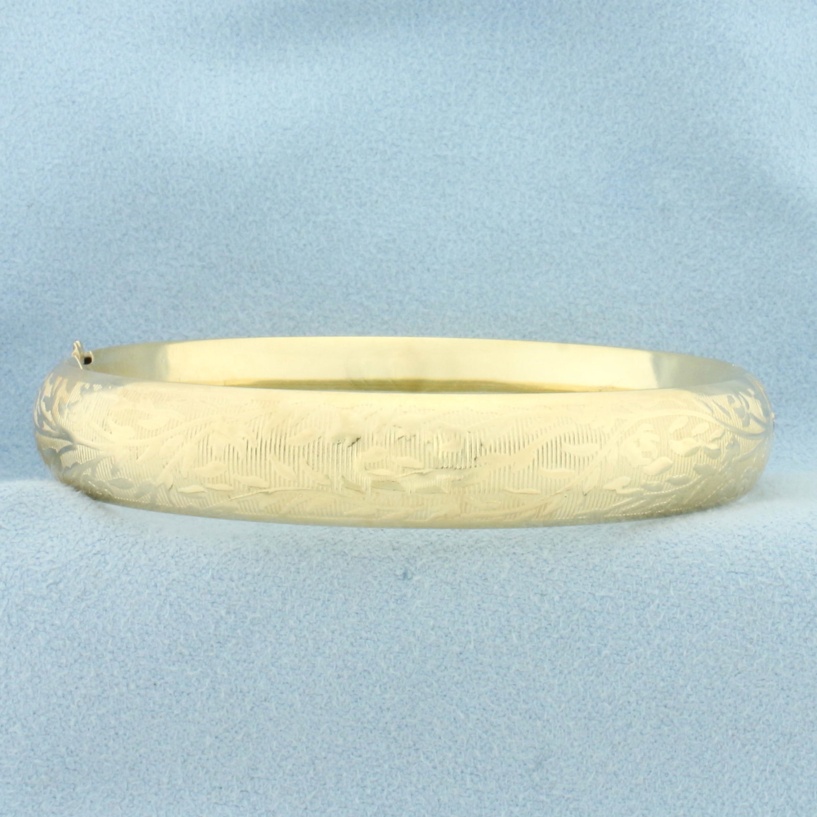 Nature Flower Design Engraved Hinged Bangle Bracelet in 14k Yellow Gold: In 14k yellow gold. 10.6mm wide. Hinged design. Interior dimensions: 2 1/4 inches by 2 1/8 inches. 14.5g.