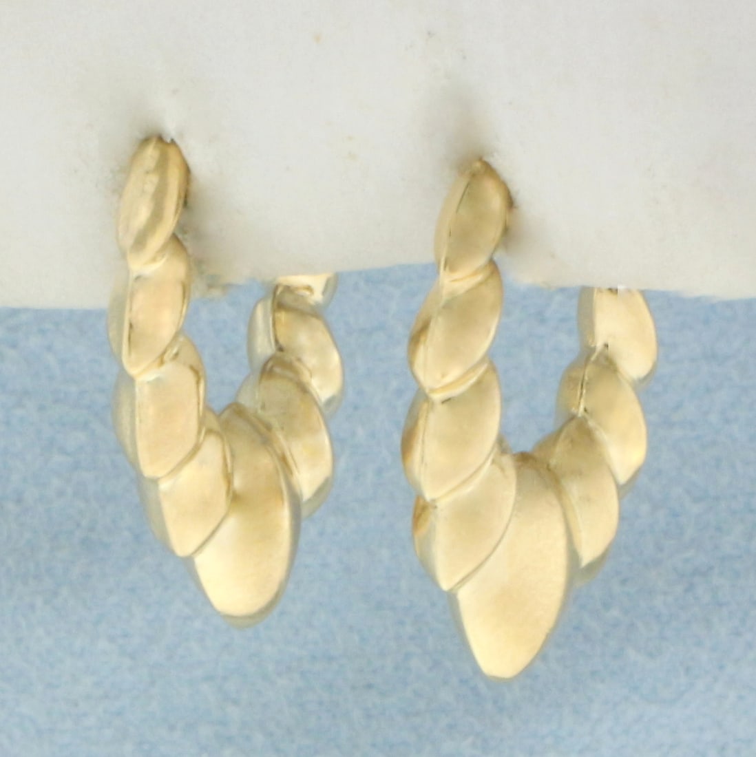 Scalloped Shrimp Hoop Earrings in 14k Yellow Gold: In 14k Yellow Gold. 133/4 inch long. 1/2 inch wide. Note posts are slightly different as shown in picture. 1.3g.