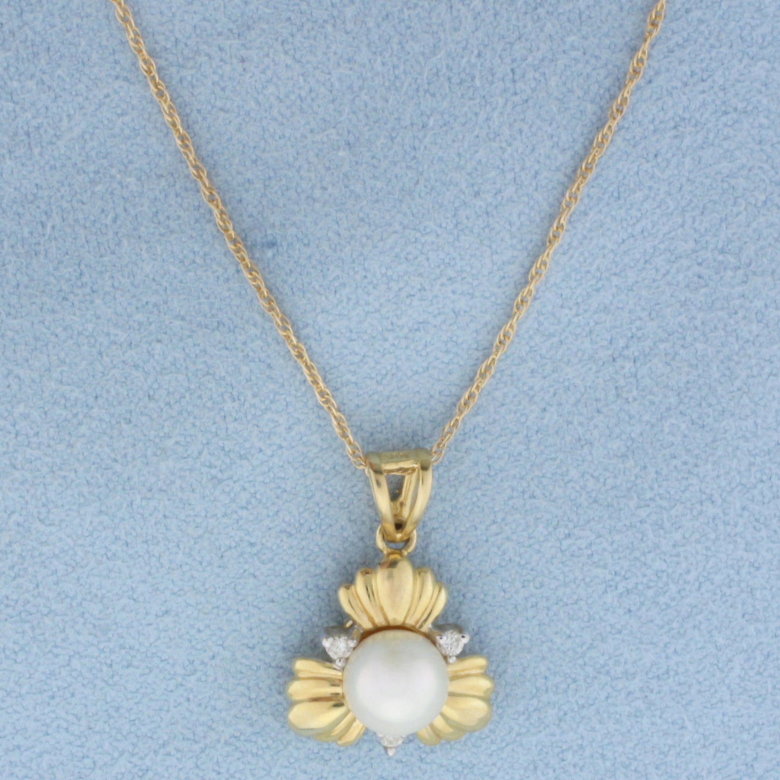 Akoya Pearl and Diamond Necklace in 14k Yellow Gold: In 14k yellow gold. Contains one high quality 6.4mm cultured Akoya pearl with high luster. Also contains three high quality .01ct diamonds, SI clarity/H color. Pendant is 3/4 inches long and 1/2 inche