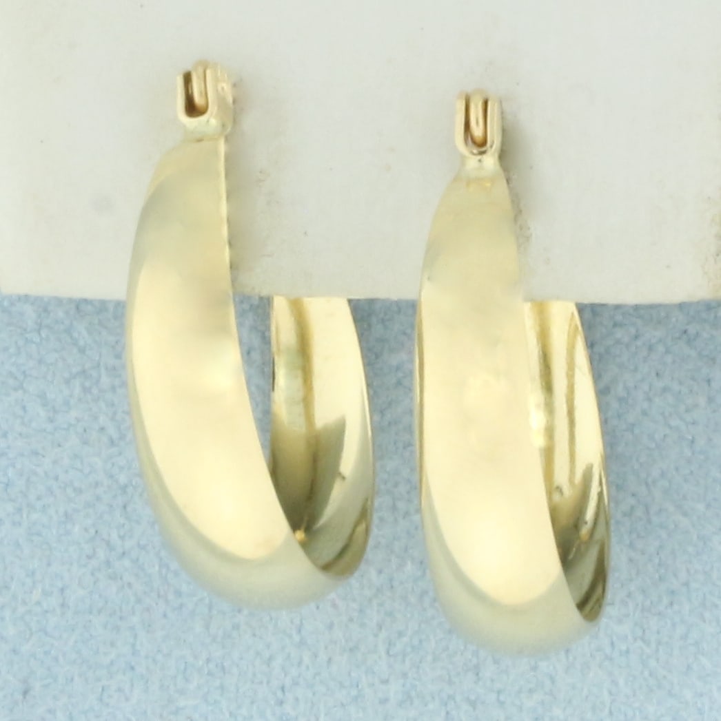 Hoop Earrings in 14k Yellow Gold: In 14k Yellow Gold. 3/4 inch long. 5.3mm wide at widest. Locking leverbacks. 2.0g.