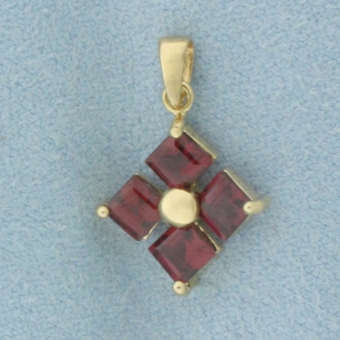 Garnet Pendant in 14k Yellow Gold: In 14k Yellow Gold. Contains four high quality 4mm natural garnet gemstones with intense color and excellent clarity. 3/4 inch long. 1/2 inch wide. 1.2g.