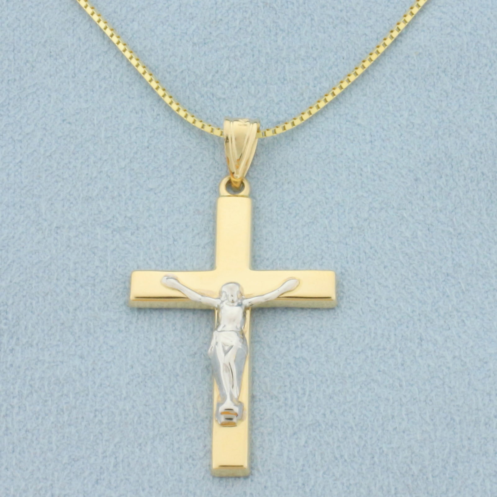 Italian Crucifix Necklace in 14k Yellow Gold: In 14k Yellow Gold, White Gold Accent on Crucifix. Crucifix is 1 1/2 inch long (including bale) by 7/8 inch wide. Box link chain is 24 1/2 inches long by .7mm wide. Italian made. 4.1g.