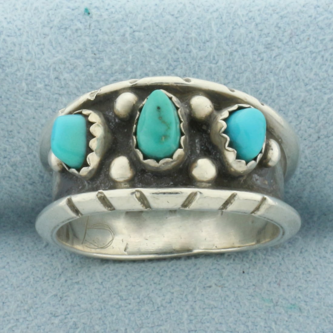 Signed Native American Turquoise Ring in Sterling Silver: In .925 Sterling Silver. Contains three high quality natural Turquoise gemstone pieces. 11.6mm wide at center. Signed "M" with bear claw symbol. Size 8.5. 5.8g.