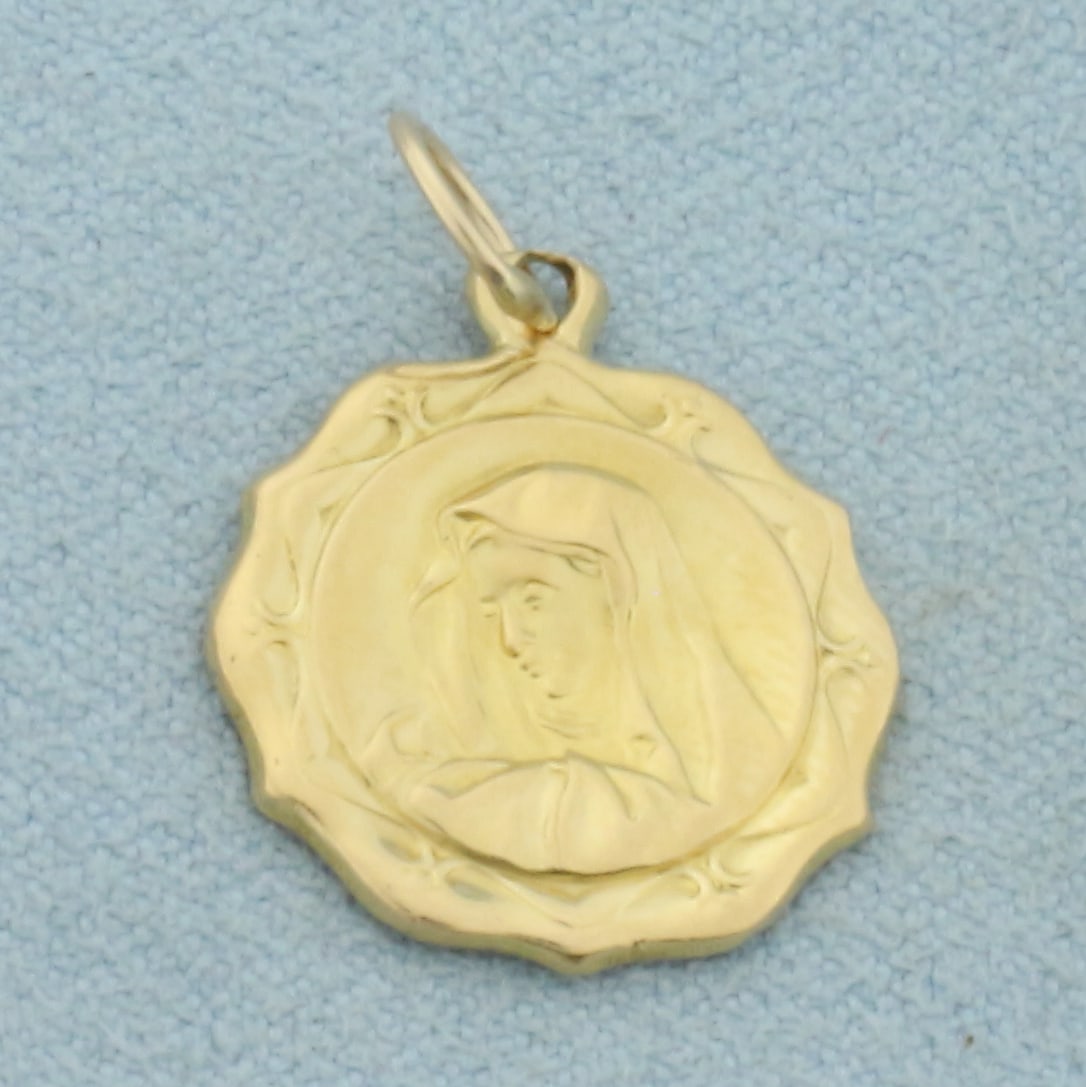 Madonna Virgin Mary Charm or Pendant in 18k Yellow Gold: In 18k Yellow Gold. 7/8 inch long. 5/8 inch wide. 1.4g.