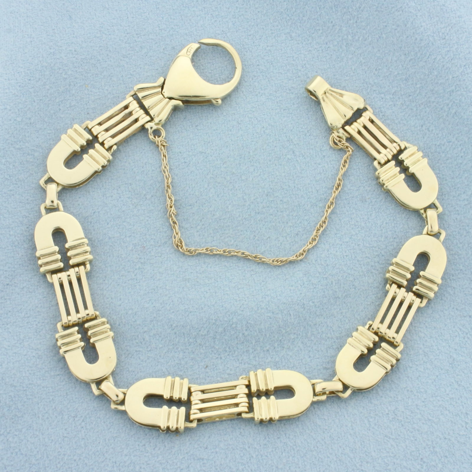 Italian Designer Horseshoe Link Bracelet in 14k Yellow Gold: In 14k Yellow Gold. 7 5/8 inches long. 3/8 inch wide. Italian made. Oversized lobster clasp with safety chain. 16.8g.