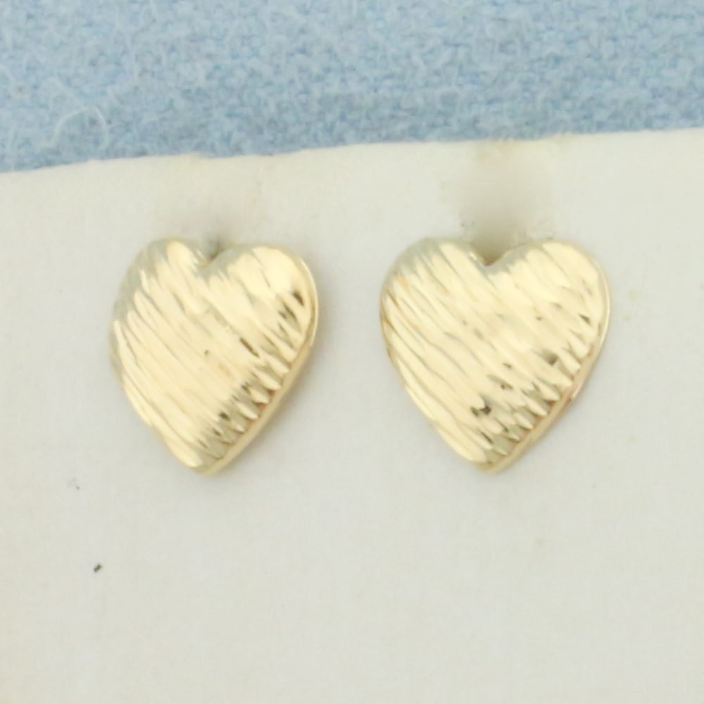 Child Heart Earring in 14k Yellow Gold: In 14k Yellow Gold. 8mm long/wide. Diamond cut detailing. Friction backs. .3g.